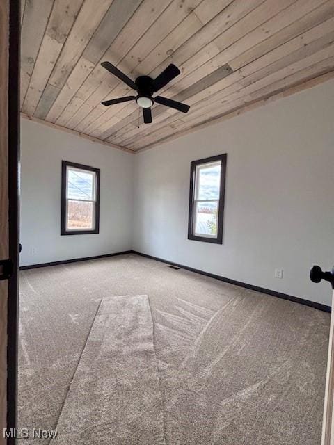 carpeted empty room with wooden ceiling, baseboards, and ceiling fan