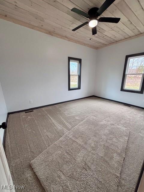 spare room with wooden ceiling, baseboards, and carpet floors