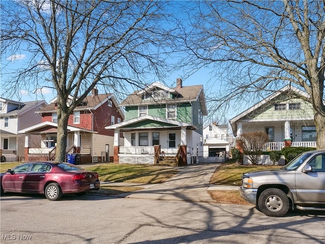 american foursquare style home featuring a residential view and a porch