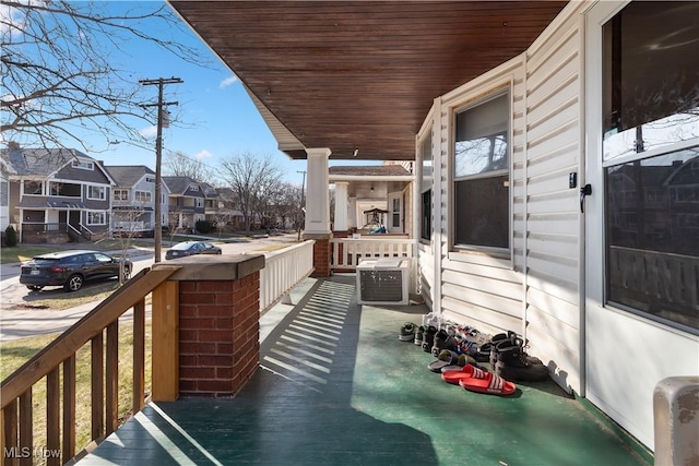 balcony featuring a residential view, a porch, and central air condition unit