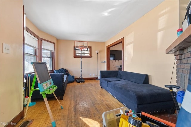 living room featuring visible vents, baseboards, and hardwood / wood-style flooring