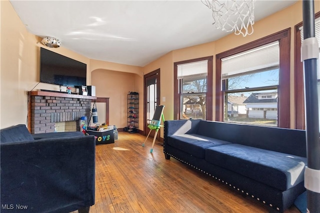 living area featuring baseboards, a fireplace, and hardwood / wood-style flooring