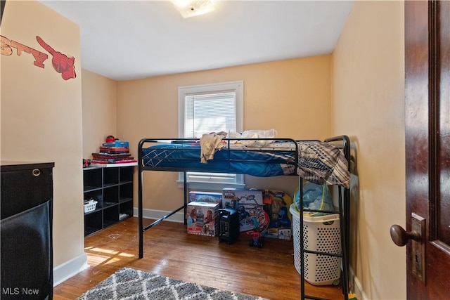 bedroom featuring baseboards and hardwood / wood-style flooring