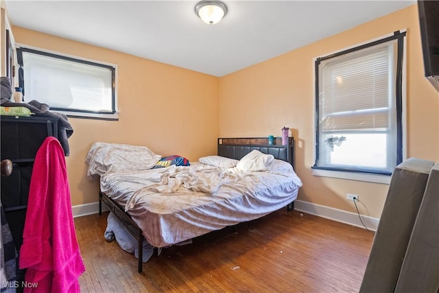 bedroom with hardwood / wood-style floors and baseboards