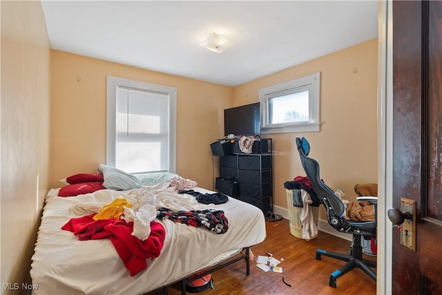 bedroom featuring baseboards and wood finished floors