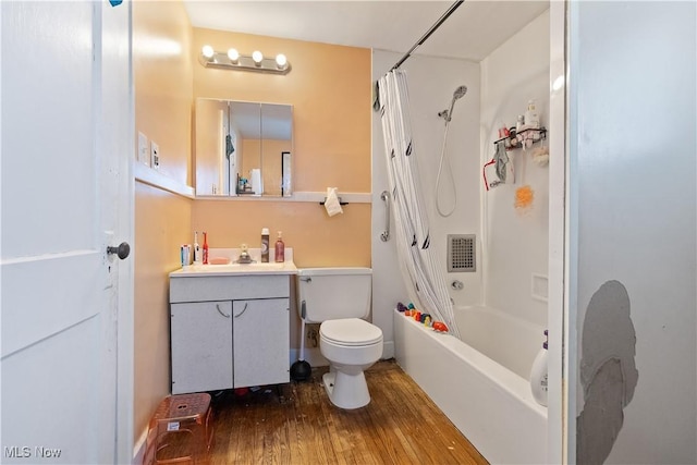 bathroom featuring visible vents, shower / bath combo with shower curtain, toilet, wood finished floors, and vanity