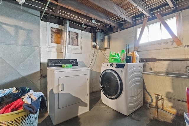 washroom with a sink, laundry area, electric panel, and washer and clothes dryer