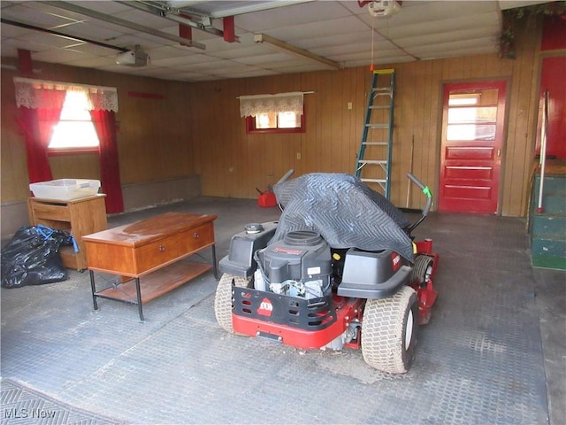 garage featuring a garage door opener and wood walls