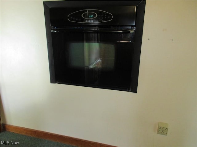 interior details featuring black oven and baseboards