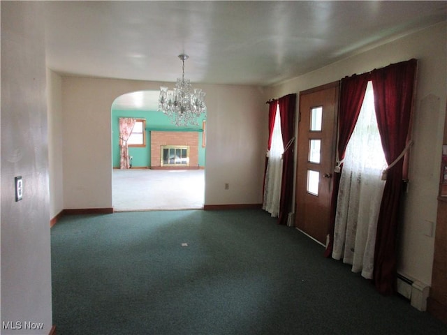 carpeted foyer featuring arched walkways, an inviting chandelier, a baseboard heating unit, and a wealth of natural light