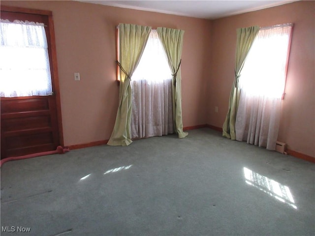 carpeted spare room featuring baseboards