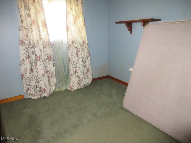 carpeted spare room featuring baseboards