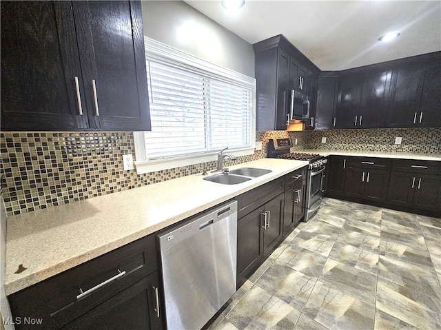 kitchen featuring light countertops, tasteful backsplash, appliances with stainless steel finishes, and a sink