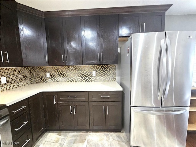 kitchen with backsplash, light countertops, and freestanding refrigerator