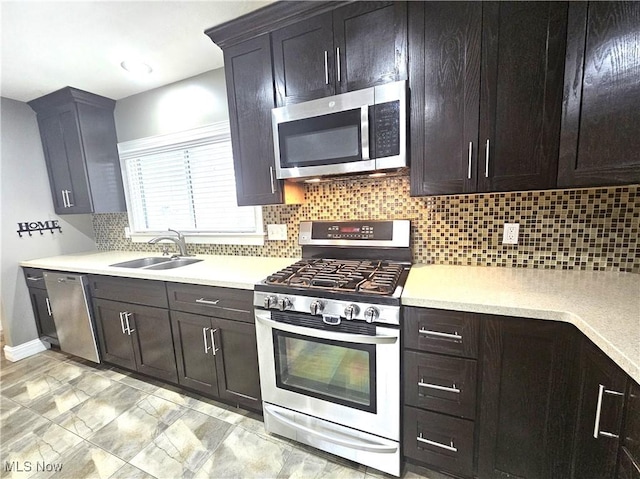 kitchen featuring a sink, decorative backsplash, appliances with stainless steel finishes, and light countertops