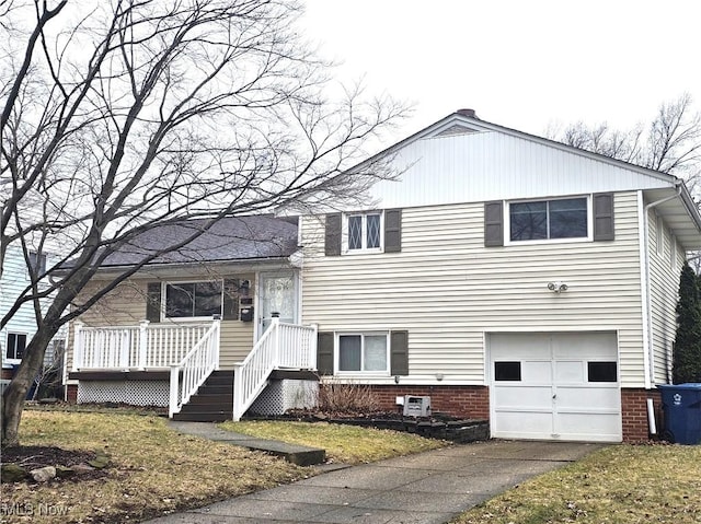 split level home with aphalt driveway and an attached garage