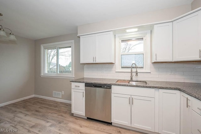 kitchen featuring tasteful backsplash, visible vents, dishwasher, stone countertops, and a sink