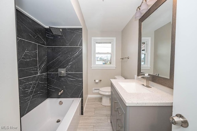 bathroom with vanity, shower / bathing tub combination, toilet, and baseboards