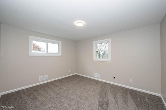 unfurnished room with carpet flooring, plenty of natural light, baseboards, and visible vents