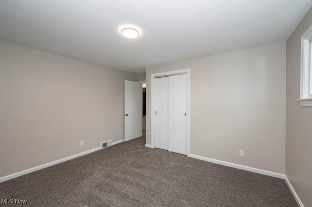 unfurnished bedroom featuring a closet, baseboards, visible vents, and carpet flooring