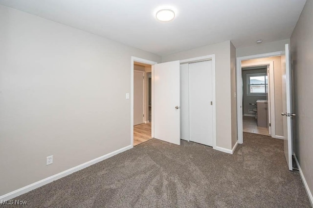 unfurnished bedroom featuring a closet, baseboards, and carpet floors