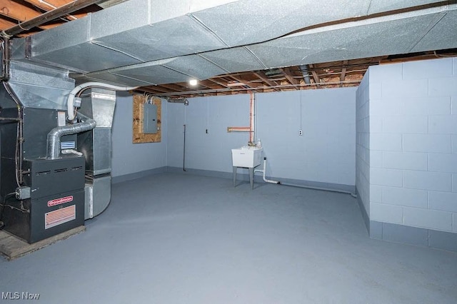 unfinished basement featuring electric panel, heating unit, concrete block wall, and a sink