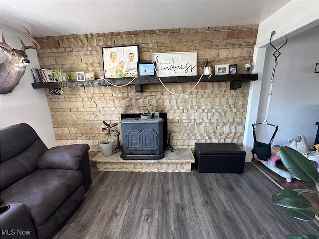 living area with wood finished floors and a wood stove