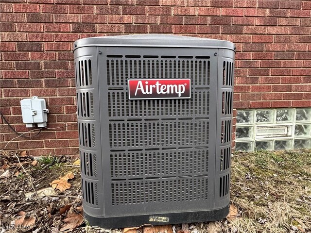 exterior details featuring central AC unit and brick siding