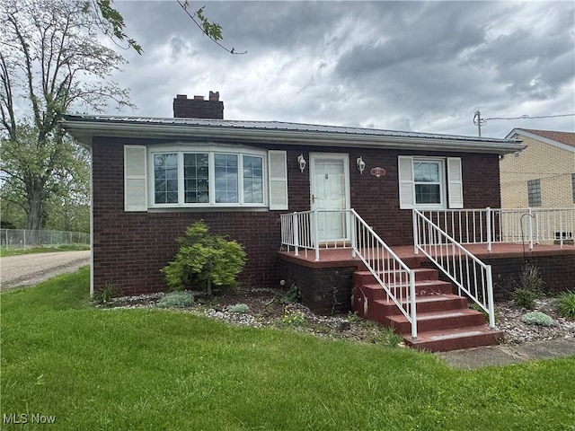 241 Summit Ave, Mingo Junction, OH 43938 - bungalow with a chimney, brick siding, and a front lawn