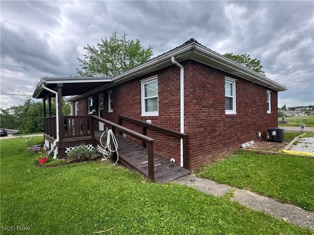 241 Summit Ave, Mingo Junction, OH 43938 - view of home's exterior with a lawn, brick siding, and central AC
