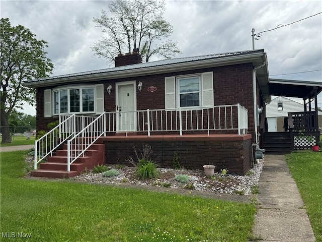 241 Summit Ave, Mingo Junction, OH 43938 - view of front facade with a chimney, brick siding, a porch, and a front lawn