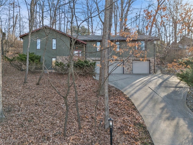 1580 Salway Ave SW, North Canton, OH 44709 - chalet / cabin with stone siding, a chimney, concrete driveway, and an attached garage