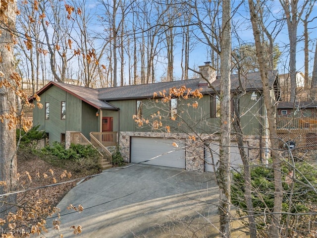 1580 Salway Ave SW, North Canton, OH 44709 - view of front of property with an attached garage, a shingled roof, a chimney, stone siding, and driveway