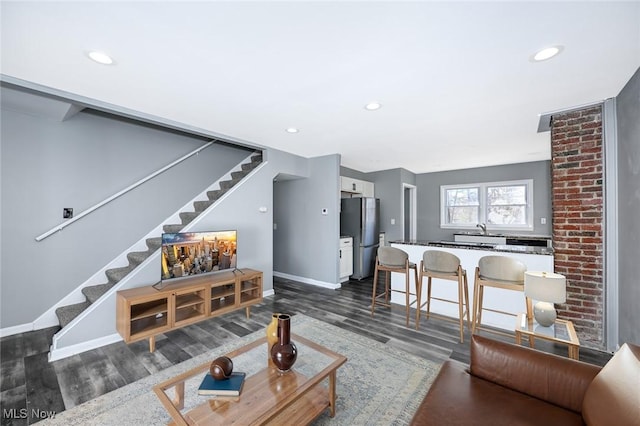 living area with stairs, recessed lighting, baseboards, and dark wood-type flooring