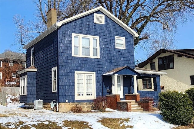 view of front facade featuring central air condition unit and a chimney