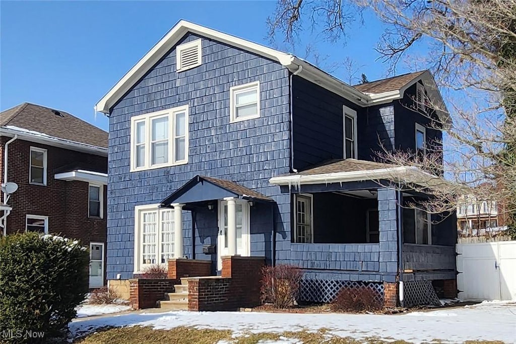 view of front of property with a porch and fence