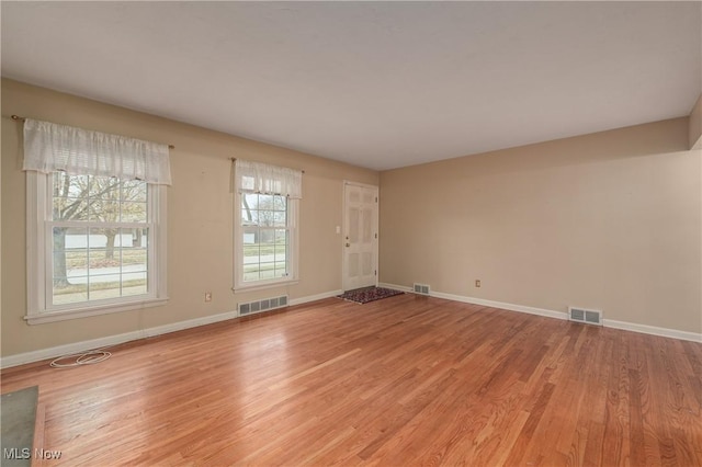 unfurnished room with visible vents and light wood-type flooring