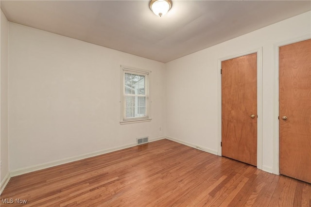 unfurnished bedroom with visible vents, baseboards, and light wood-style flooring