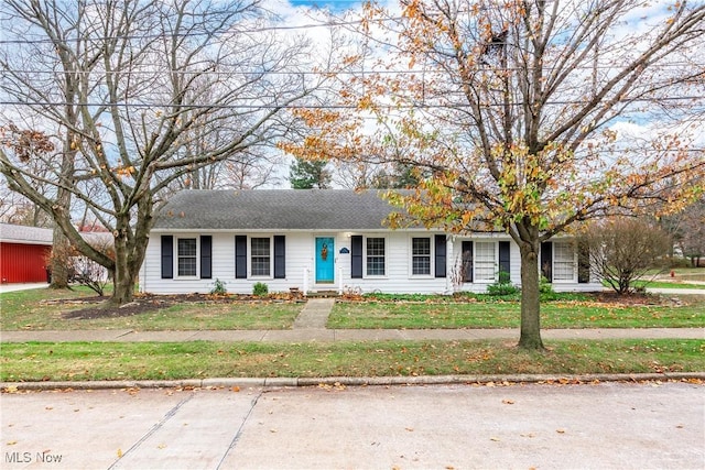 view of front of property with roof with shingles and a front lawn