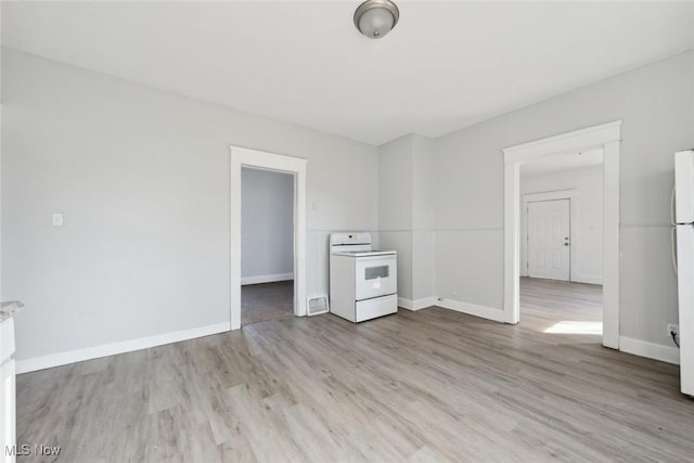 unfurnished room with light wood-style flooring and baseboards