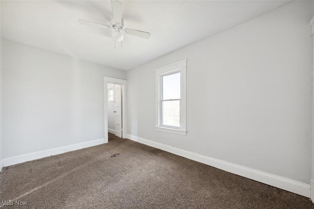 spare room with carpet, baseboards, and ceiling fan