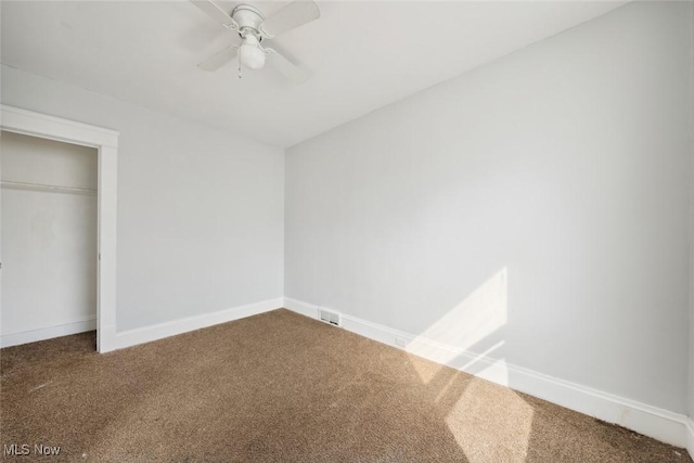 unfurnished bedroom featuring a closet, a ceiling fan, baseboards, and carpet floors