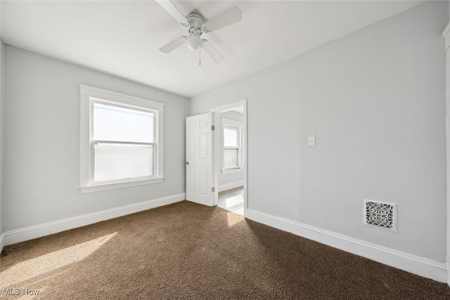 spare room with carpet flooring, baseboards, visible vents, and ceiling fan