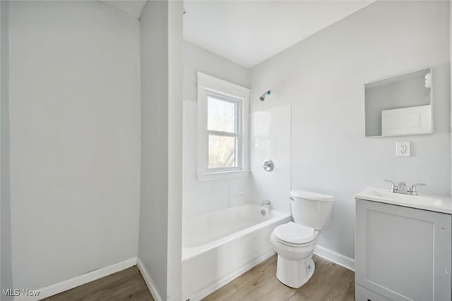 bathroom with baseboards, toilet, wood finished floors, and vanity