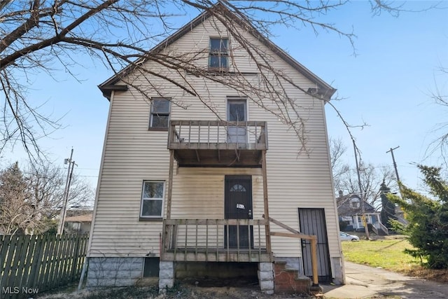 back of house with a balcony and fence