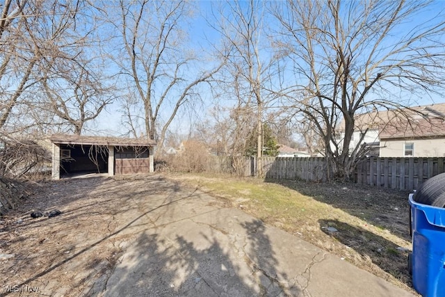 view of yard with an outdoor structure, a pole building, and fence