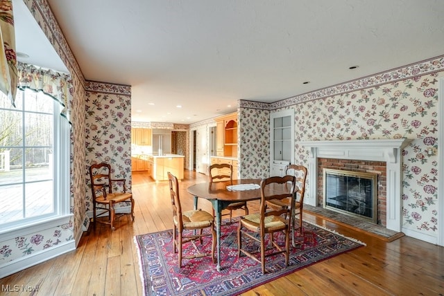 dining area featuring wallpapered walls, a healthy amount of sunlight, and baseboards