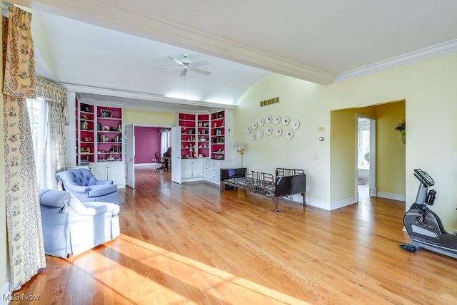 living room featuring visible vents, ornamental molding, a ceiling fan, wood finished floors, and baseboards