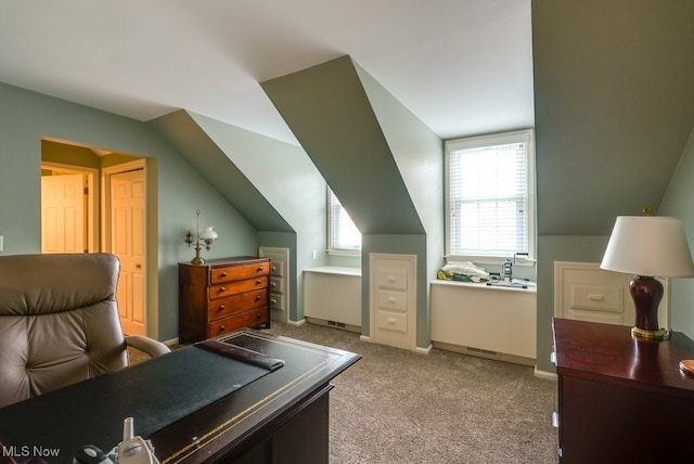 office space with lofted ceiling and light carpet