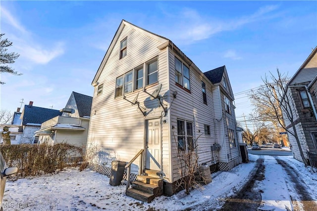 snow covered property featuring entry steps